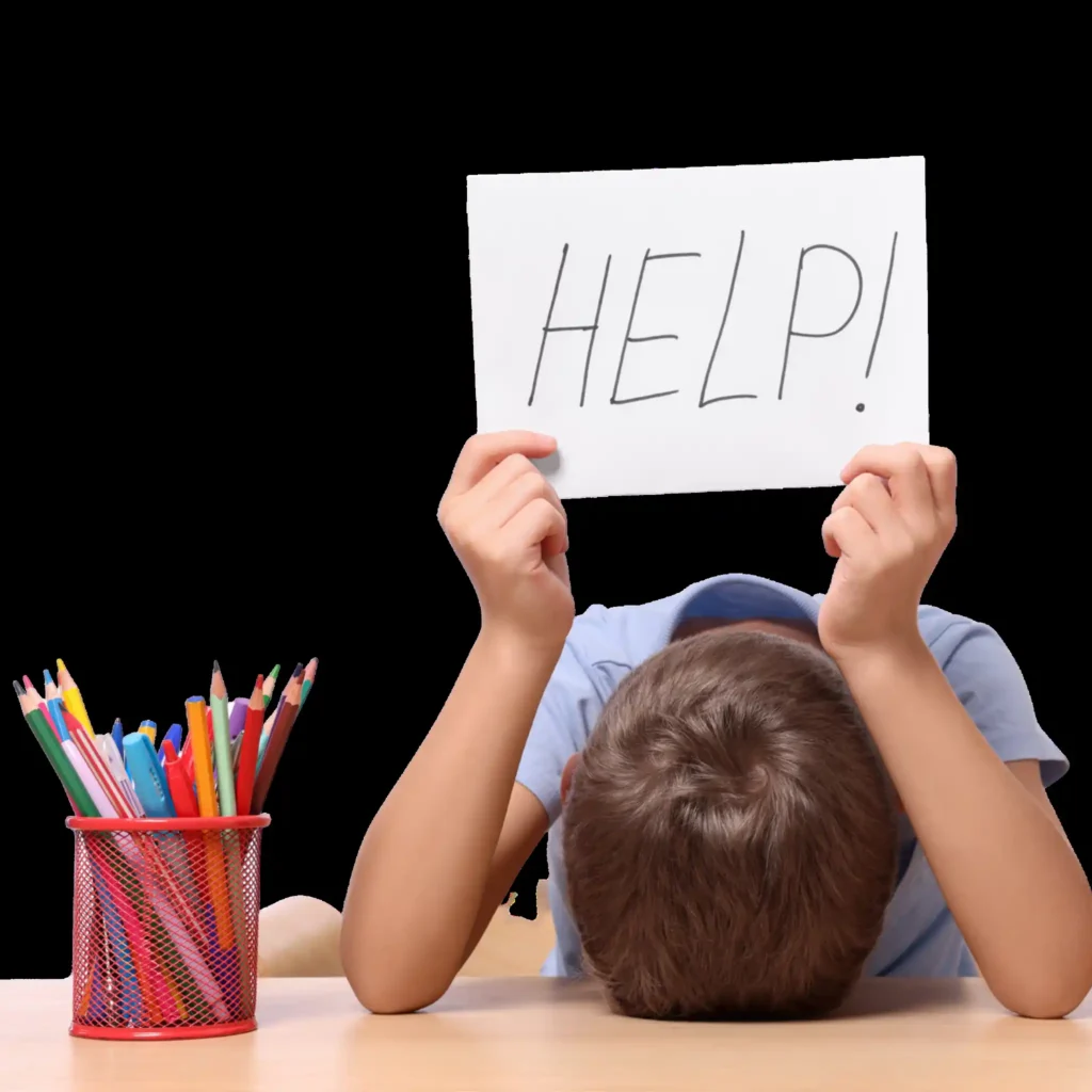 Niño en mesa con cartel de "HELP!" durante sesión de evaluación neuropsicológica en Murcia